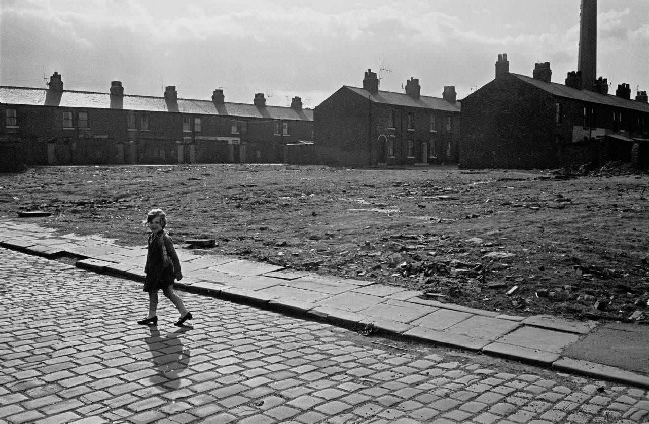 Child crossing waste ground Salford 1969