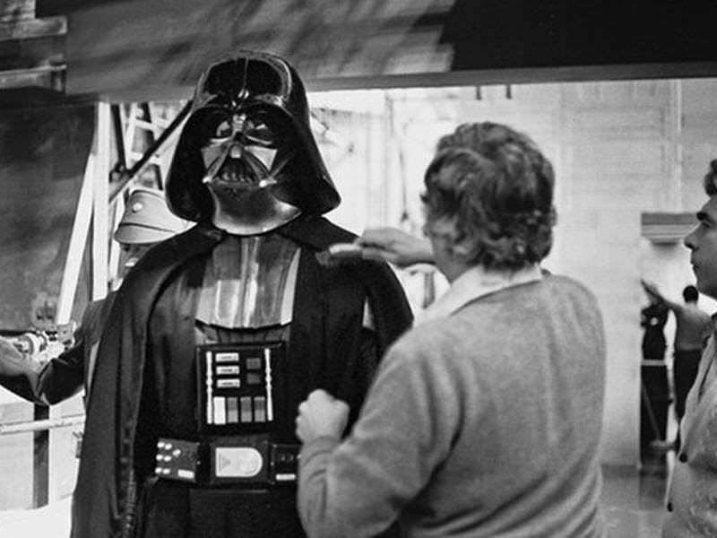 A costume designer puts the finishing touches on Darth Vader's outfit.