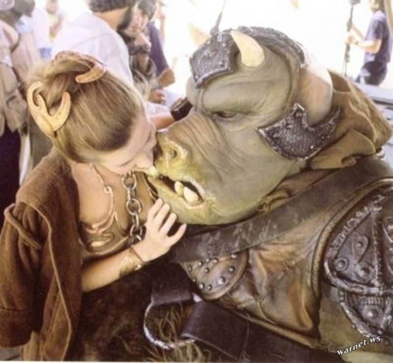 Carrie Fisher poses with a Gamorrean guard, one of Jabba the Hutt's lackeys, on the set of Return Of The Jedi.