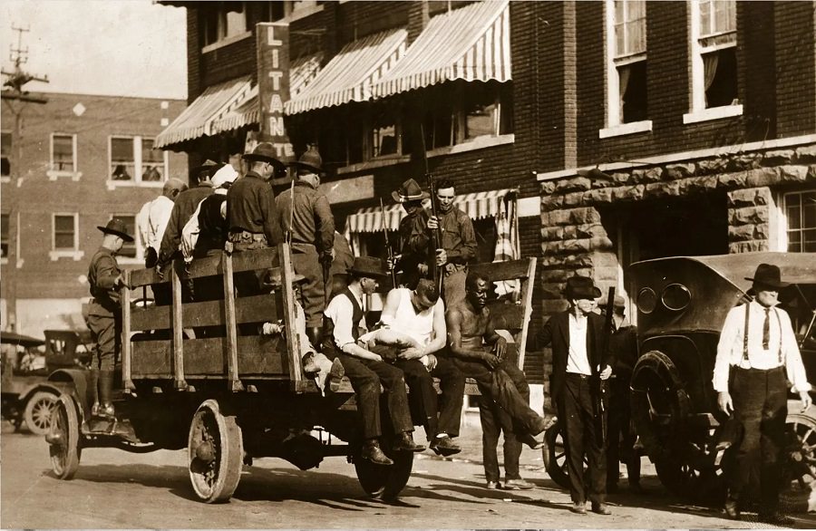 Injured and wounded men are taken to the hospital by National Guard troops on June 3, 1921.