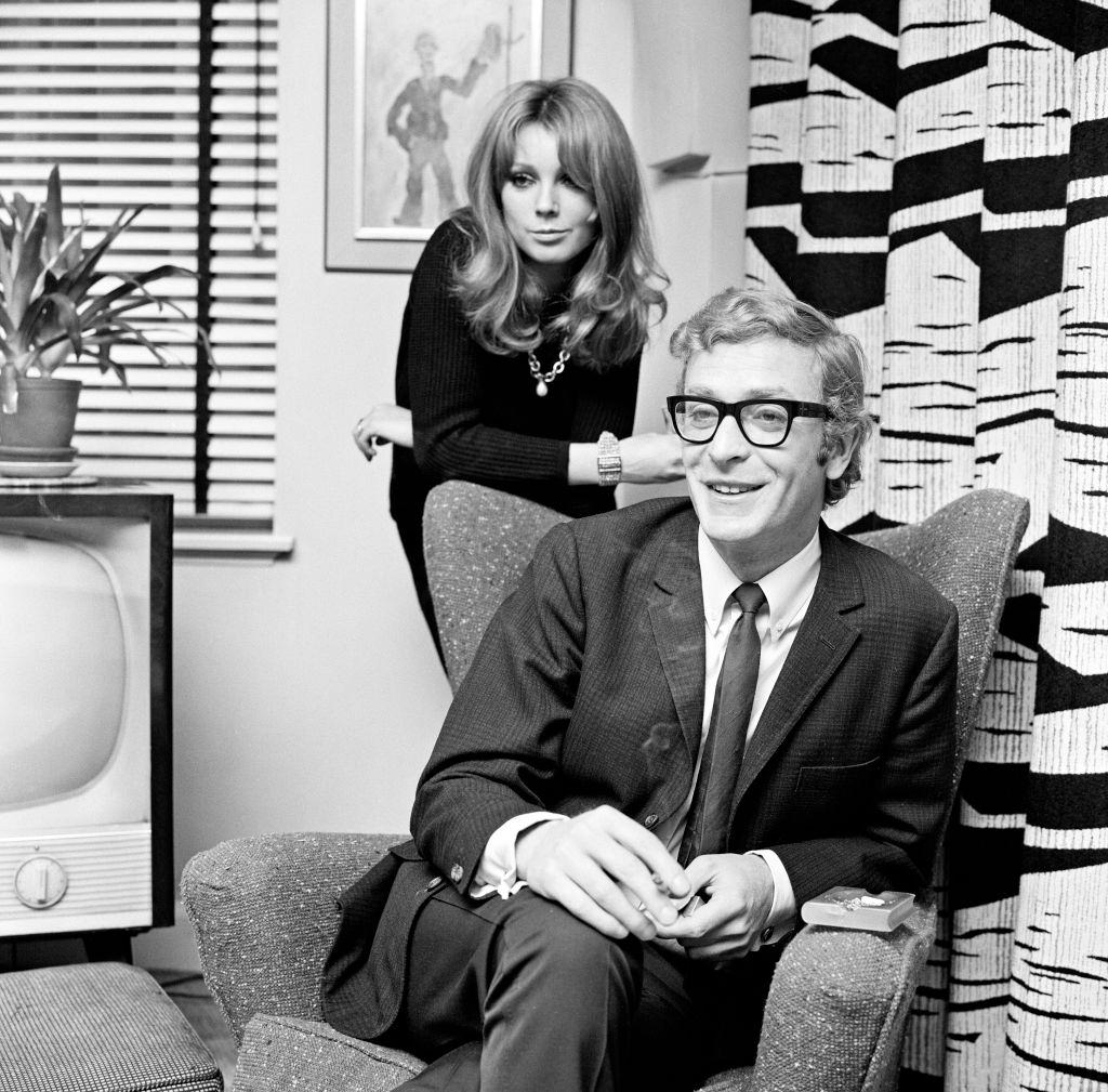 Michael Caine with French actress Miss Elizabeth Ercy in the flat of the Mirror's Donald Zec, 2nd December 1965.