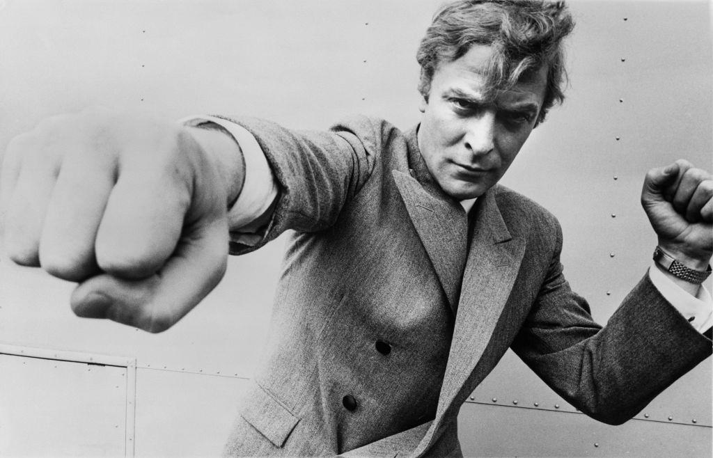 Michael Caine, throwing a punch, 1965.