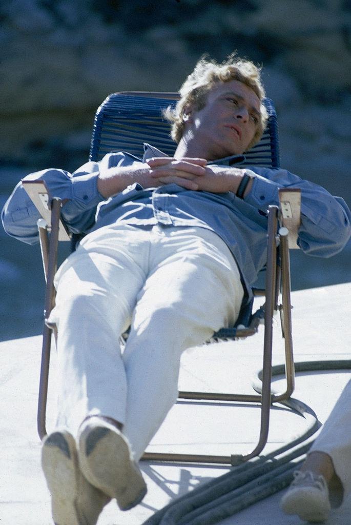 Michael Caine relaxes on the European set of 'The Magus', 1968