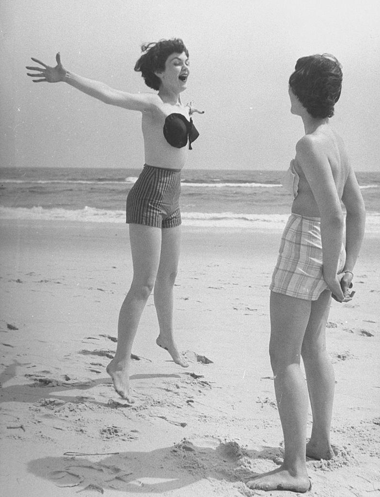 Two woman wearning wearning the adhesive bra on the beach, 1949.