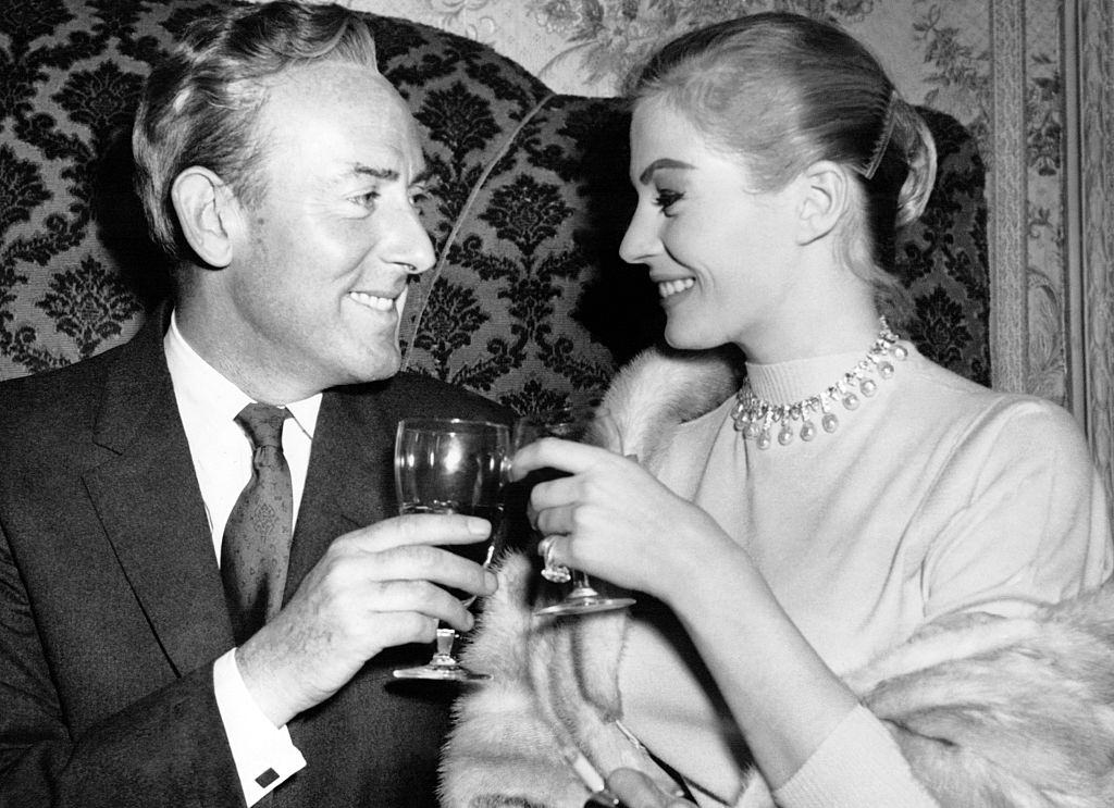 Anita Ekberg and Michael Wilding clinking glasses during a press gala diner at Hamilton Place for Terence Young's movie 'Zarak'