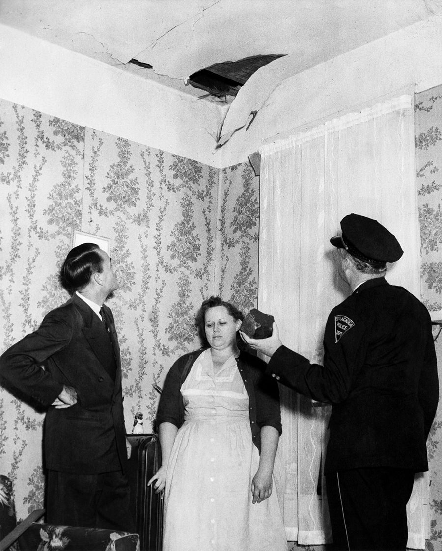 Hodges standing under the spot where the meteorite crashed through her ceiling.