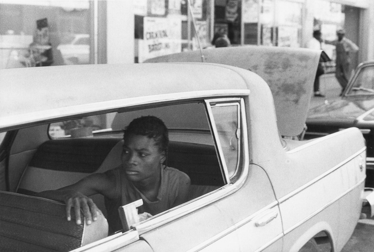 Woman in back seat of car on Water Street, 1965
