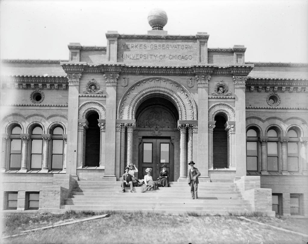 A group portrait of three women and two men outdoors on the steps of the Yerkes Observatory, a facility of the University of Chicago, 1910s.
