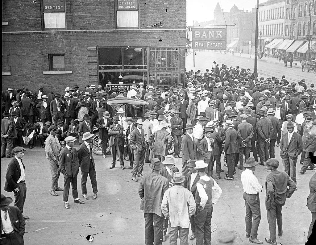Crowd in front of a storefront with the sign Bank Real Estate during the 1919 Chicago Race Riots.