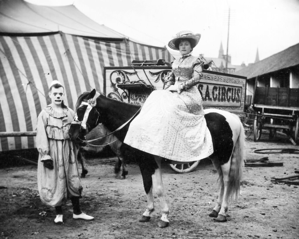 Lady on a horse, with a clown watching, 1910.