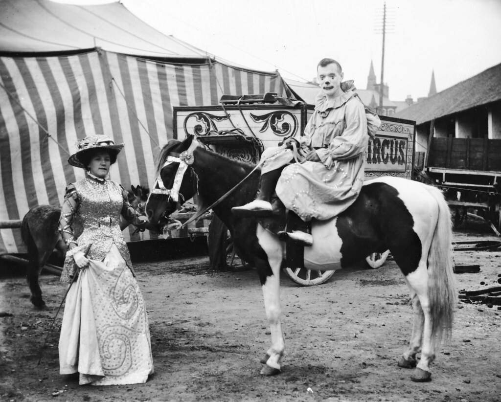 Clown on a horse, while a lady holding the horse, 1910.