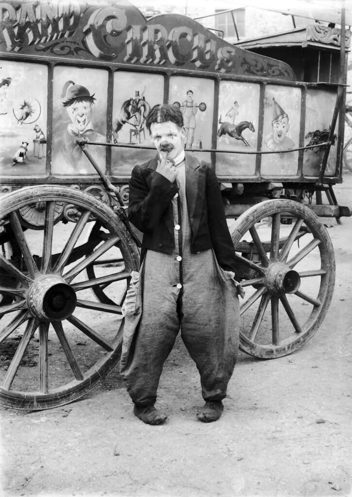 A clown beside a wagon of The Grand Circus, 1910.