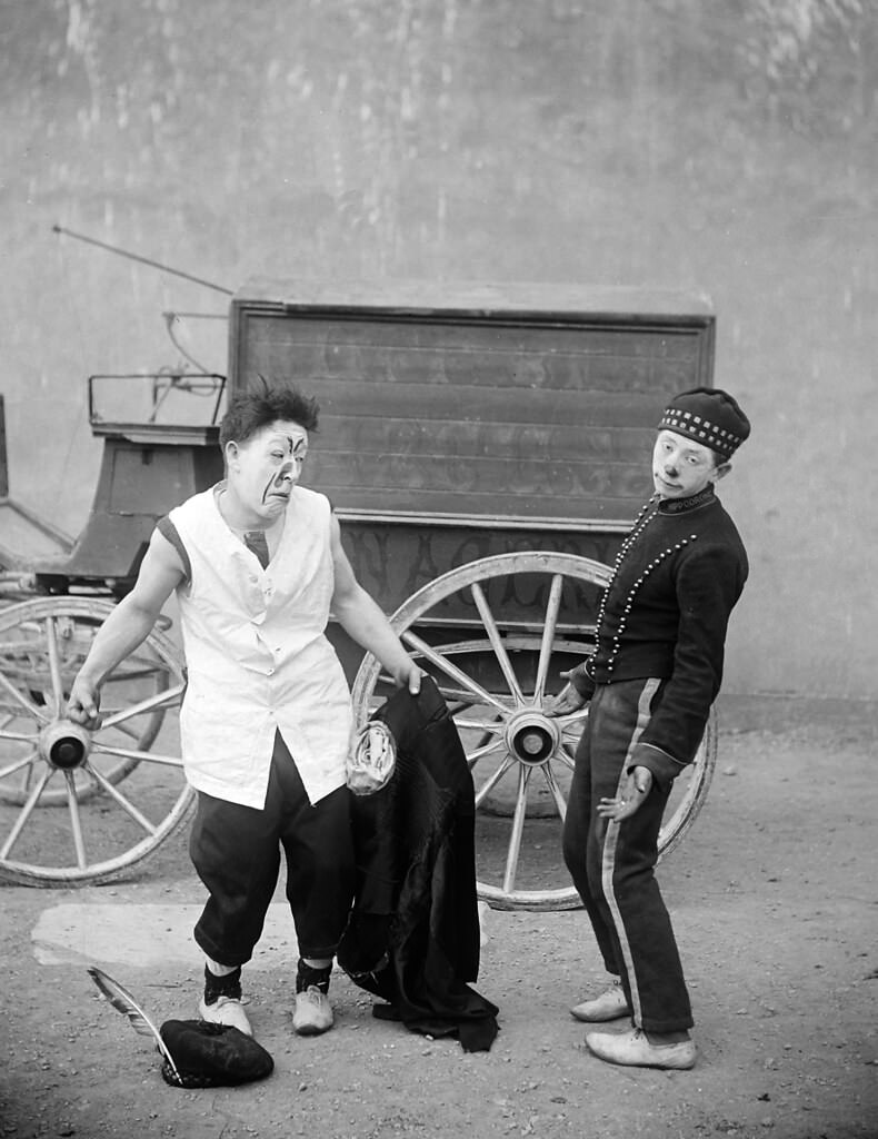 Two clowns in front of a wagon, 1910.