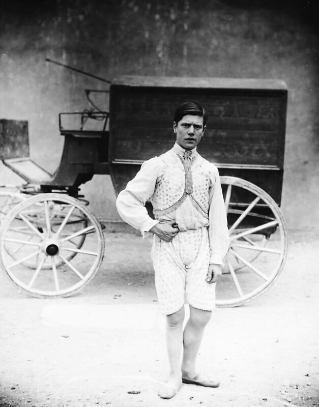 A circus performer in front of a wagon, 1910.