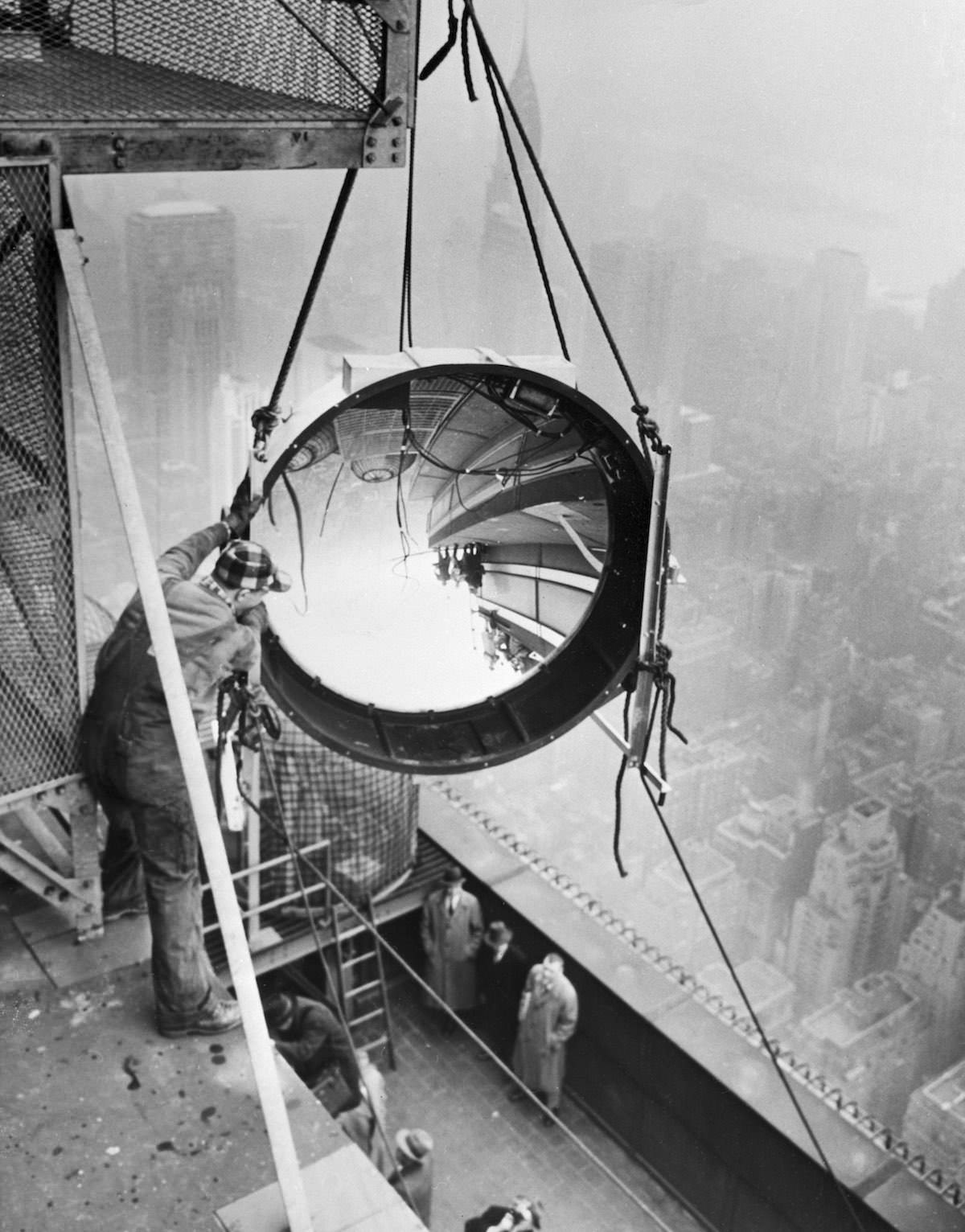 Workmen place one of the new beacon lights in position on the 90th floor of an impressive electronic crown in the form of four far-reaching night beacons.