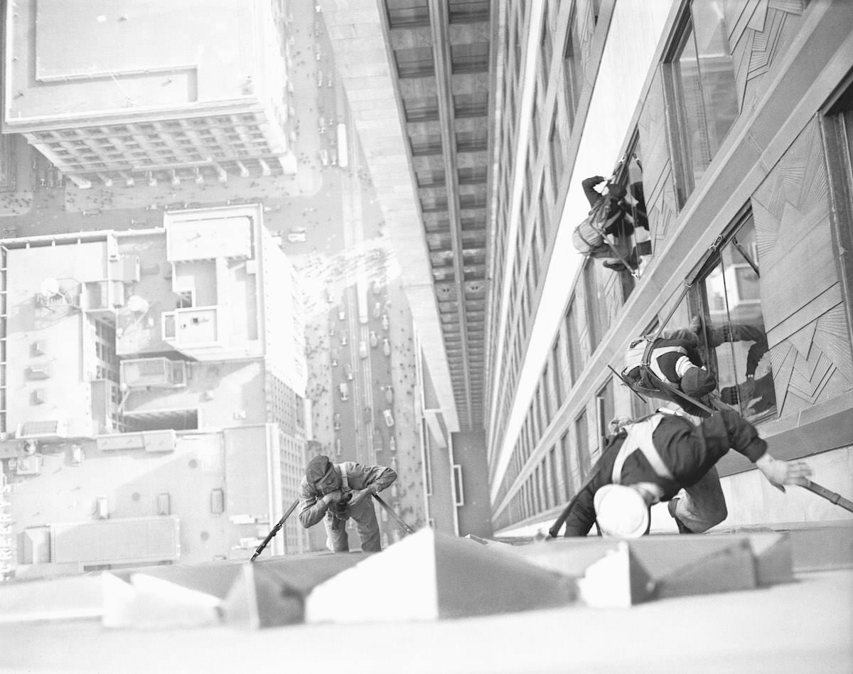 The startling 'shot' was made by the photographer looking down upon the window washers on the 34th street side of the world-famed building.