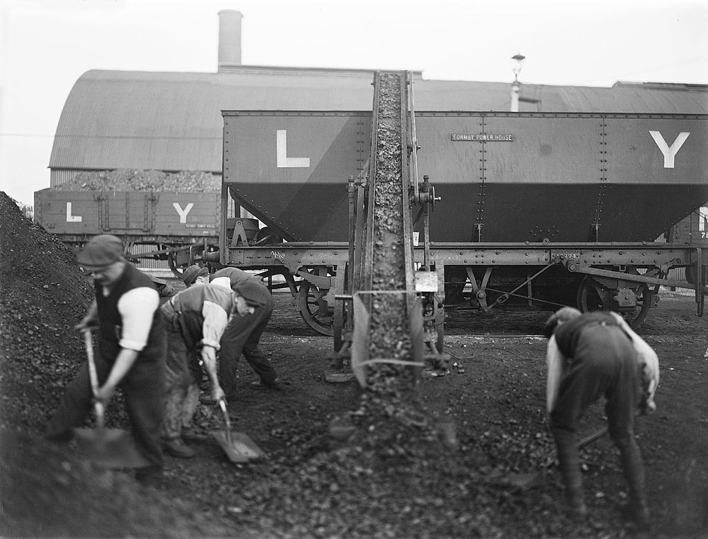 Workers shovelling coal in to a coal conveyor at Formby power station, Liverpool, 1909.