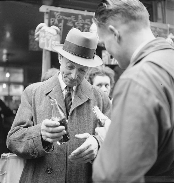 Several unidentified men drink bottles of Coca-Cola, in Paris, France.