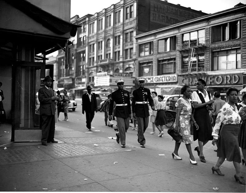 Two Marines walk down a street, 1943.