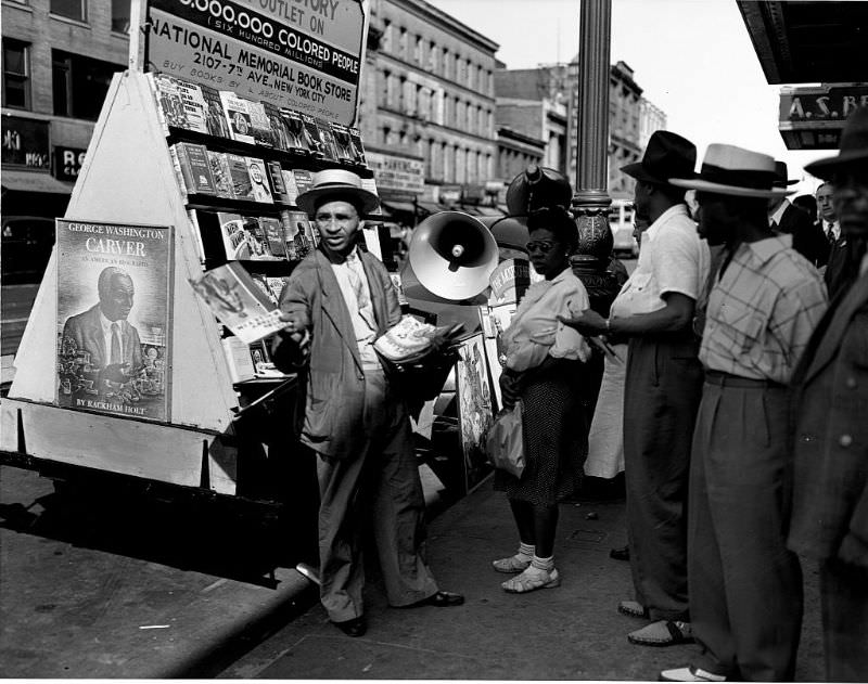 A vendor showing his wares at a bookstall on 125th Street, 1943.