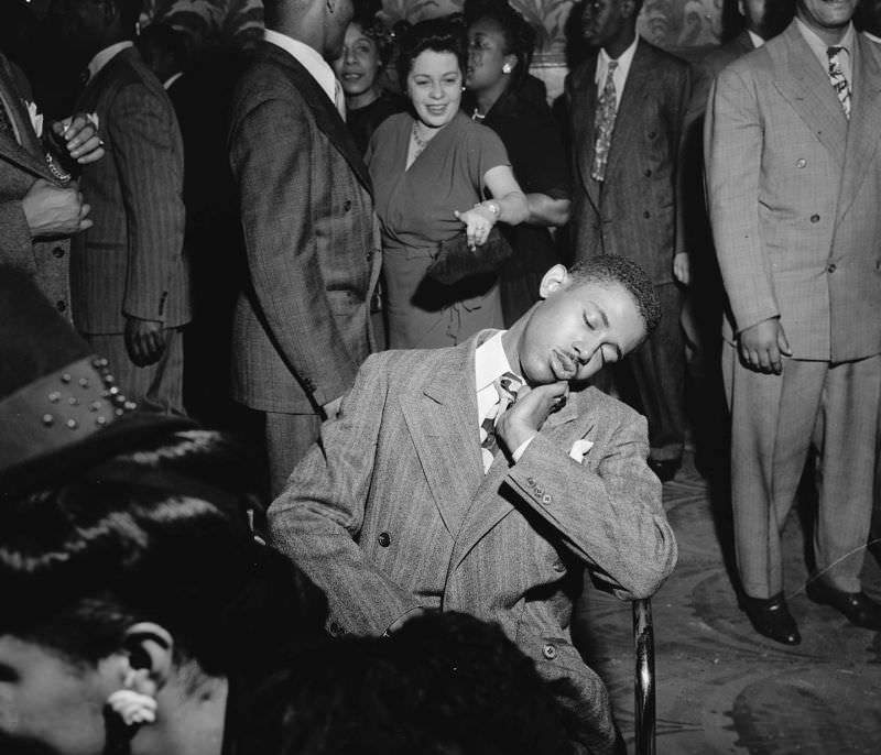 A young man falls asleep in a chair, 1945.