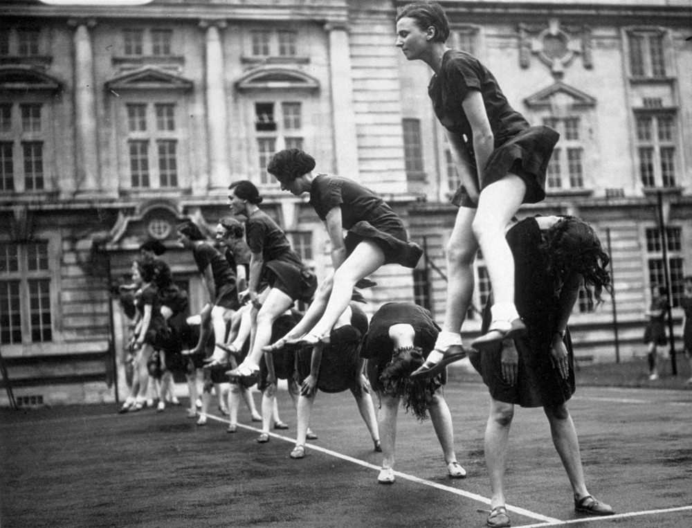Students at University College Cardiff leap frogging during a physical training display. 17th May 1936.