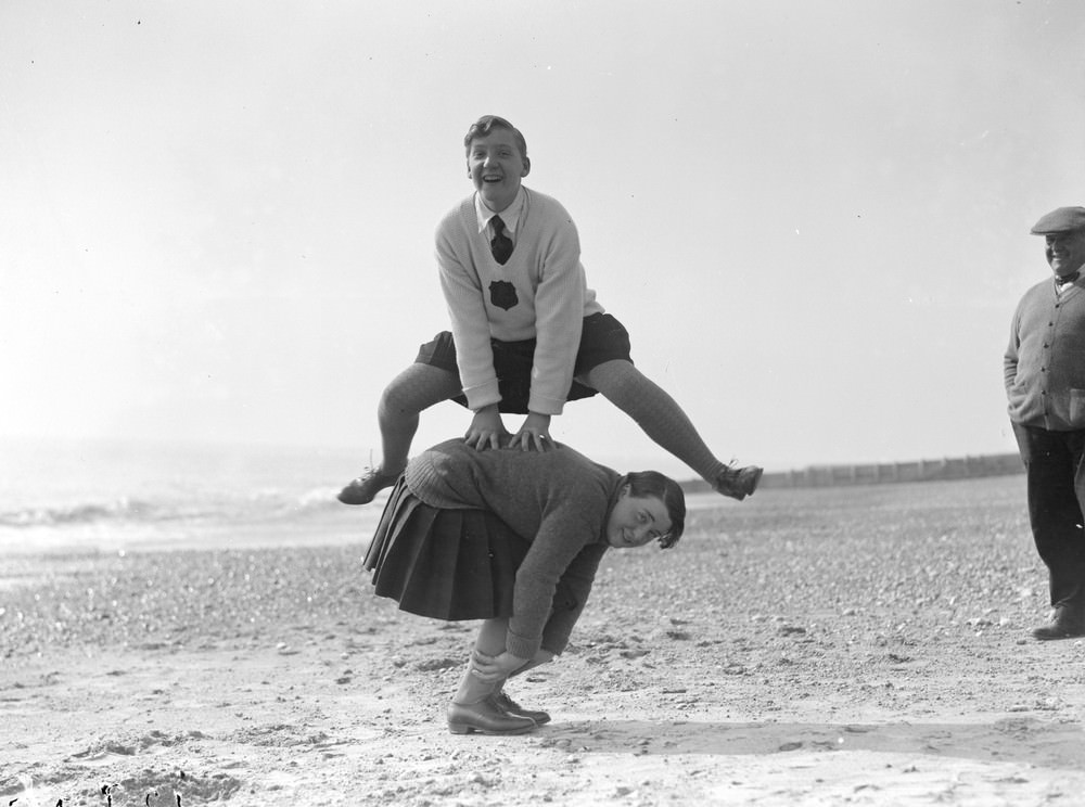 A couple of young women playing leap frog on the beach at Hove, March 1929.