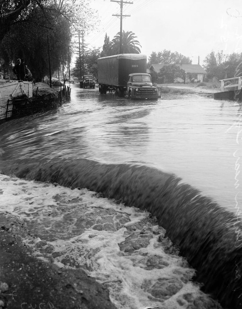 Water flowing through roads, Culver Boulevard. November 1952.