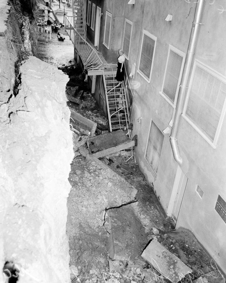 A woman looking towards a landslid near her house. November 1952.