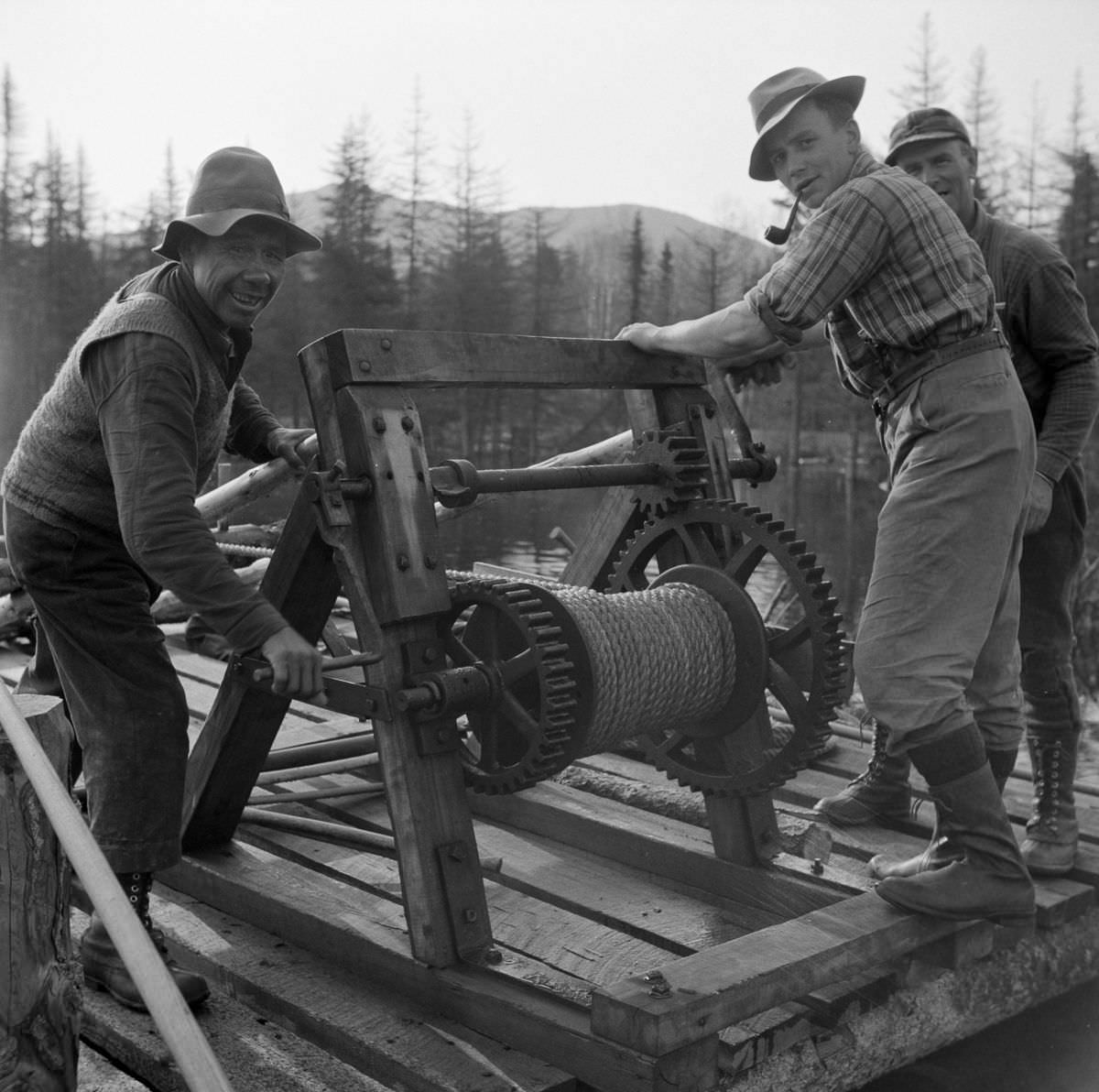 Woodsmen winching up the boom on Long Pond which guides the flow of logs downstream.