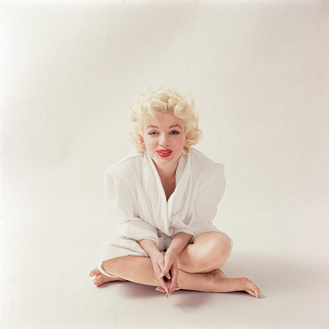 Monroe wears her favorite outfit, a white terrycloth robe, just after finishing her makeup in March 1955.