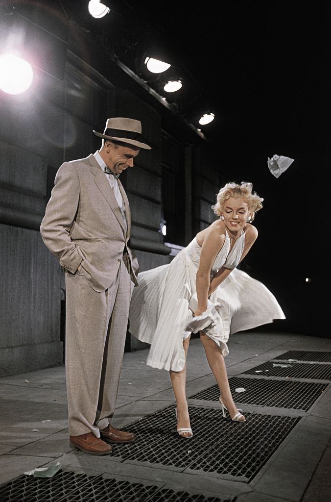 Marilyn Monroe with co-star Tom Ewell in New York Subway, while her dress was blowing from the wind.
