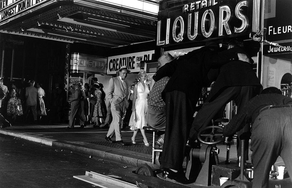 Marilyn Monroe walking with co-star Tom Ewell in front of the Trans-Lux Theater on the corner of 51st Street and Lexington Avenue while filming the famous skirt-blowing scene.