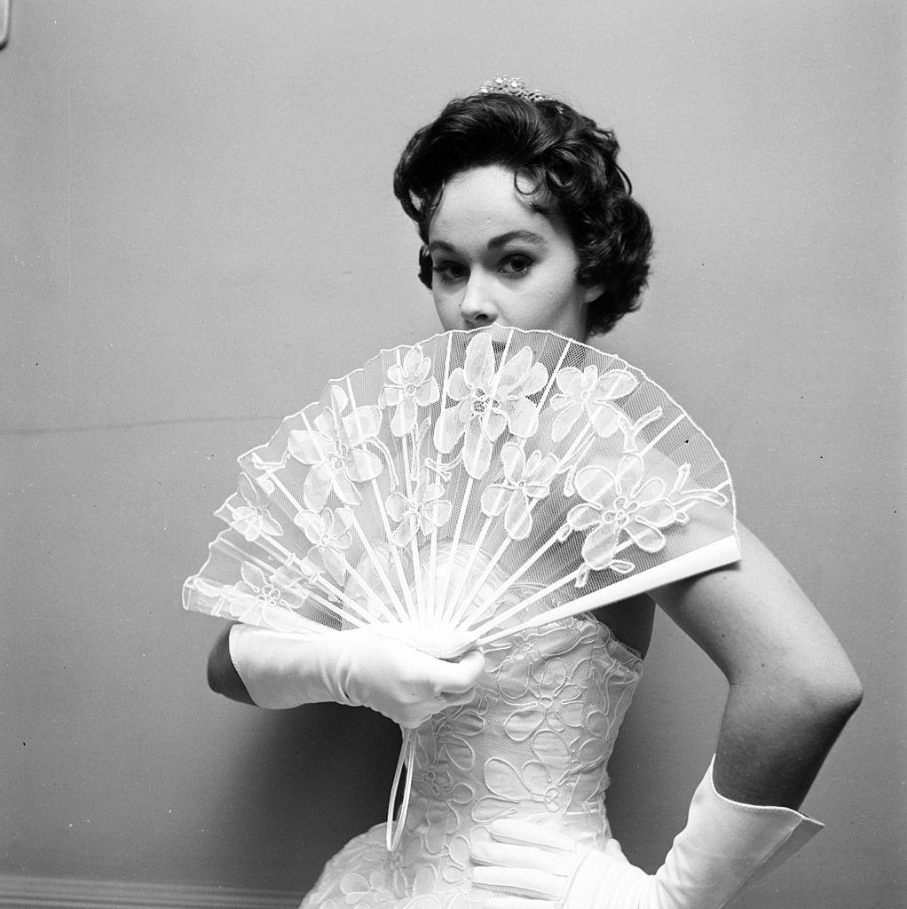 Marla English holding a wing during a fashion photoshoot, 1956.