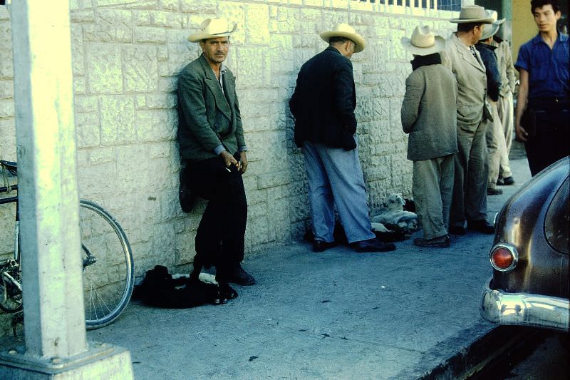 Mexican men on sidewalk, Saltillo. December 1958