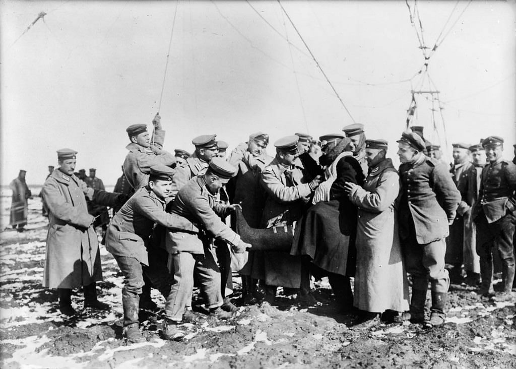 German soldiers help a high-altitude observer remove his heavy clothes, 1915.