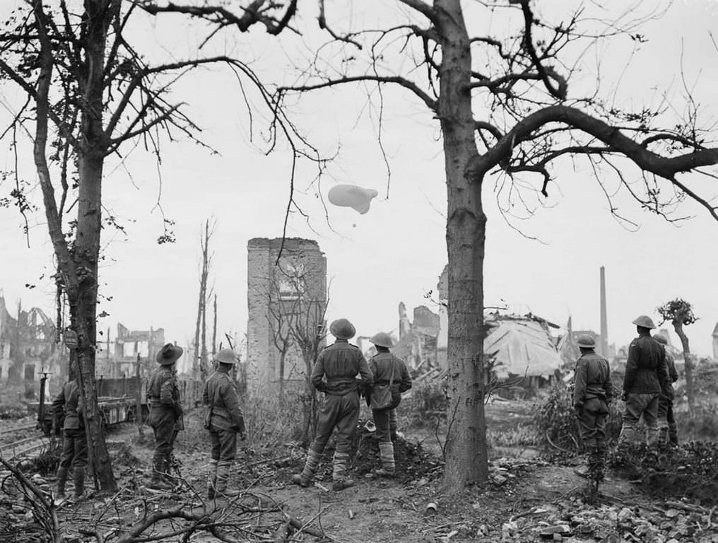 Australian soldiers watch an observation balloon ascend over Ypres, Belgium, 1917.