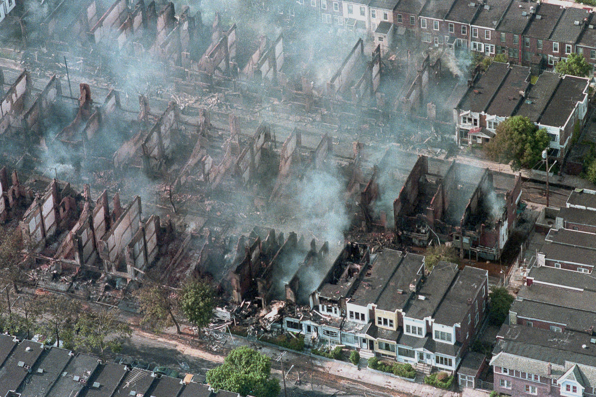 Dozens of houses continue to smolder the day after the bombing. May 14, 1985