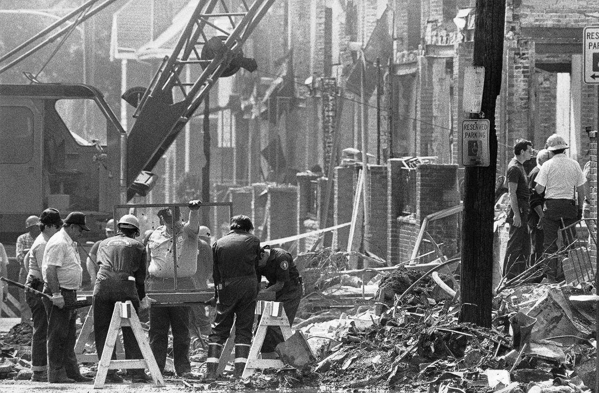 Investigators use a screen to sift through debris. May 16, 1985