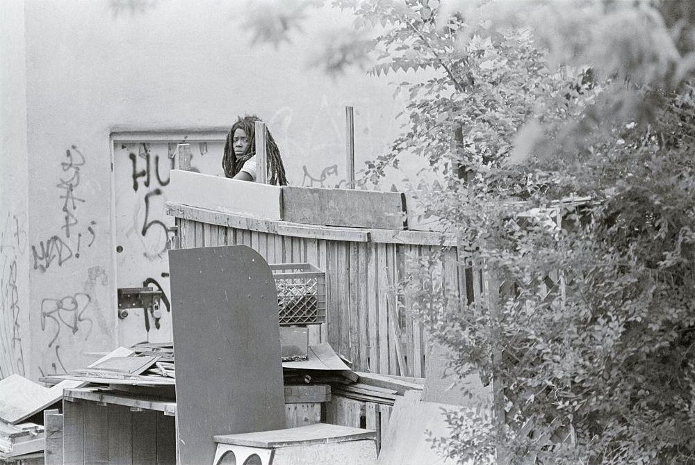 A unidentified woman living in what Philadelphia police call another MOVE house as police, newsmen and sightseers walk by by homes in the southwest section of Philadelphia.