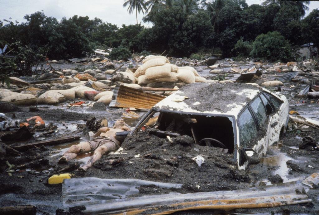 Devastation on ground level, with mud covering car, body, sandbags.