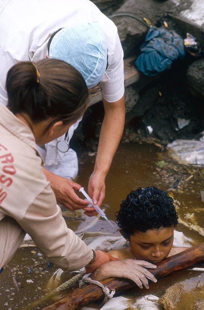 Rescuers administer a shot to Omayra Sánchez.