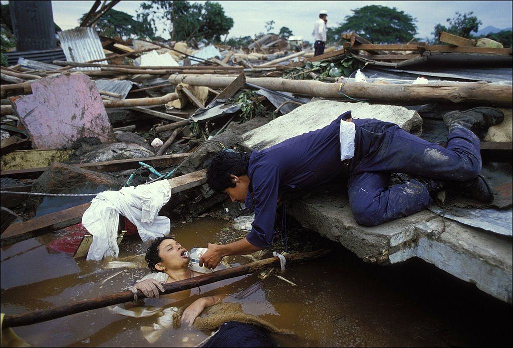 A rescuer offering water to Omayra Sánchez.