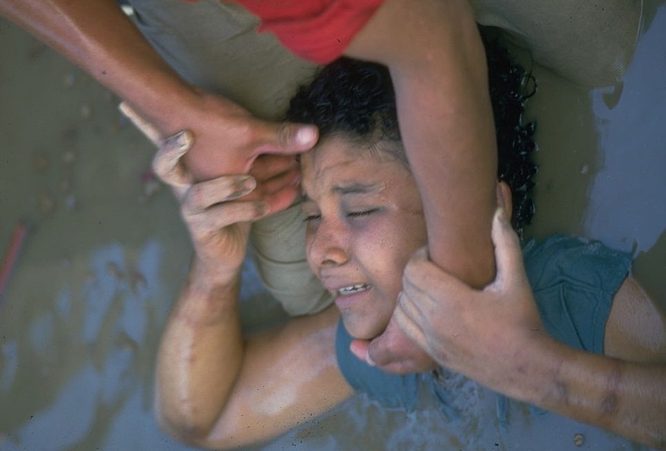 A rescuer trying to pull Omayra Sánchez.