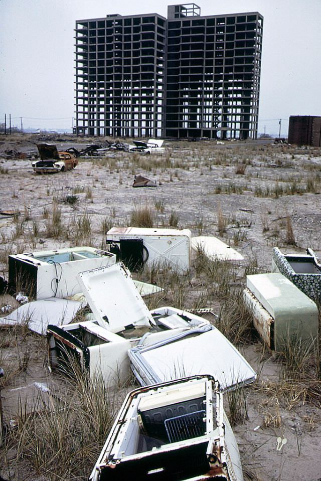 Skeleton of apartment building never completed, abandoned refrigerators and a burned out 1965 Ford Mustang, Breezy Point, Queens looking toward Brooklyn, 1973