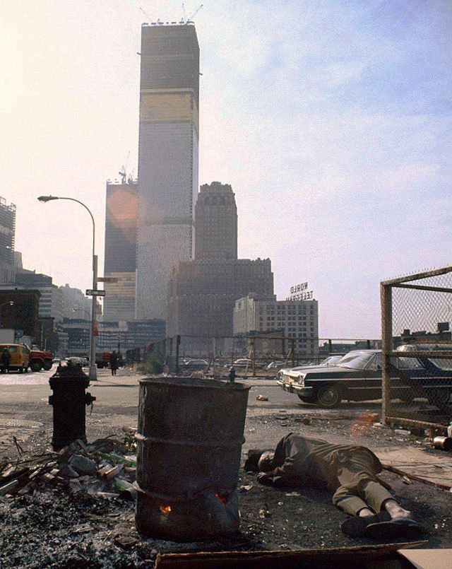 A homeless man sleeps next to a 50 gallon drum of burning scavenged wood, New York, 1970