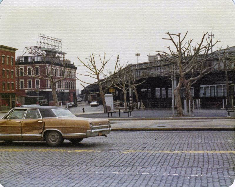 23rd St and abandoned West Side Highway, a battered Ford Galaxy 500 drives by on cobblestones, April 1975