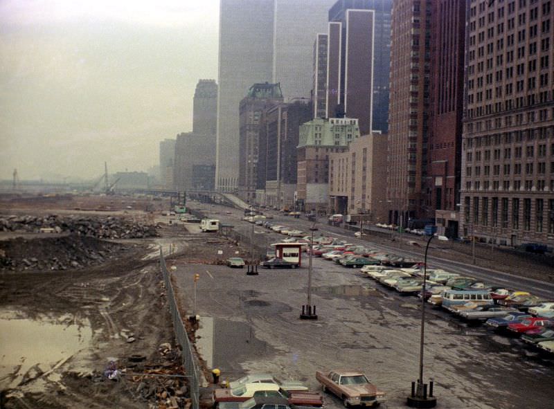 View from Pier A's fire escape, Battery Park City landfill, West Side Highway, World Trade Center and lots of colorful 1970s cars on a rainy, foggy day, 1975