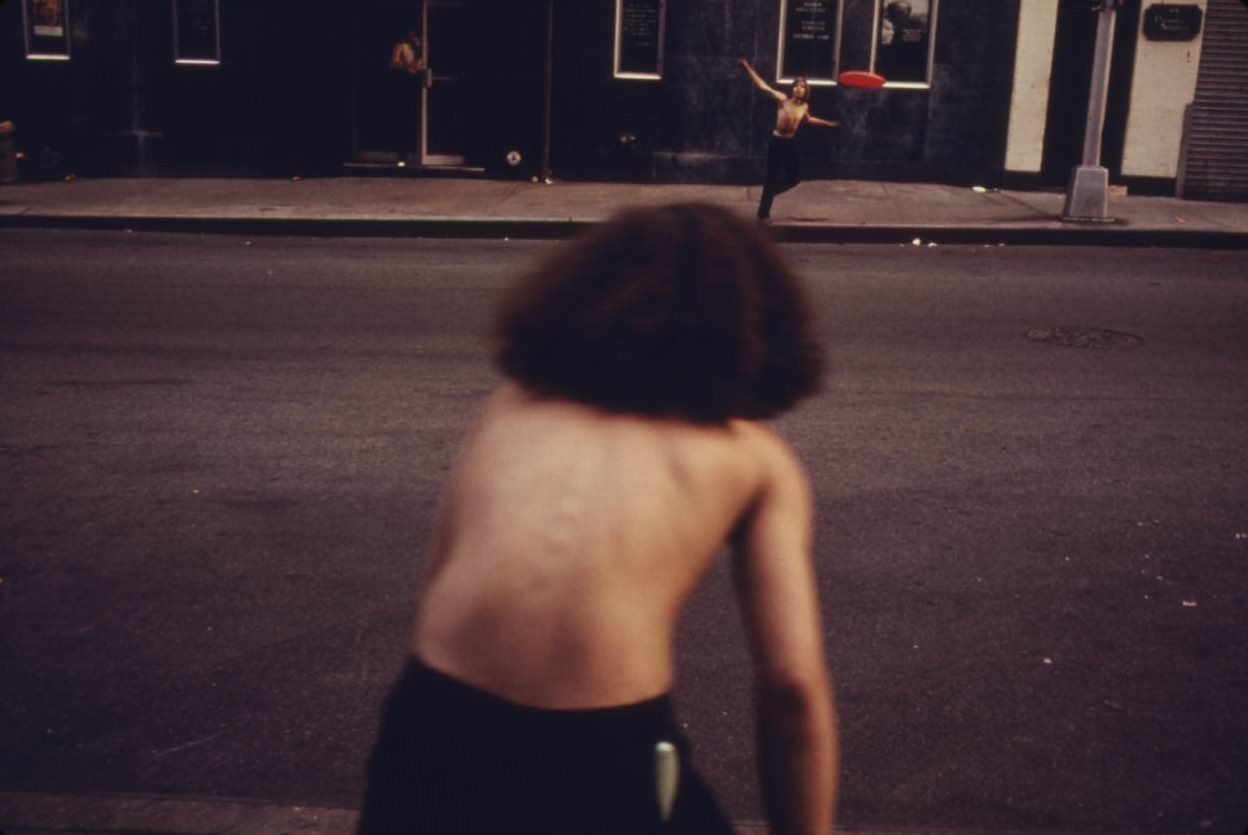 Boys playing frisbee across West 46th Street in Manhattan, July 1974.