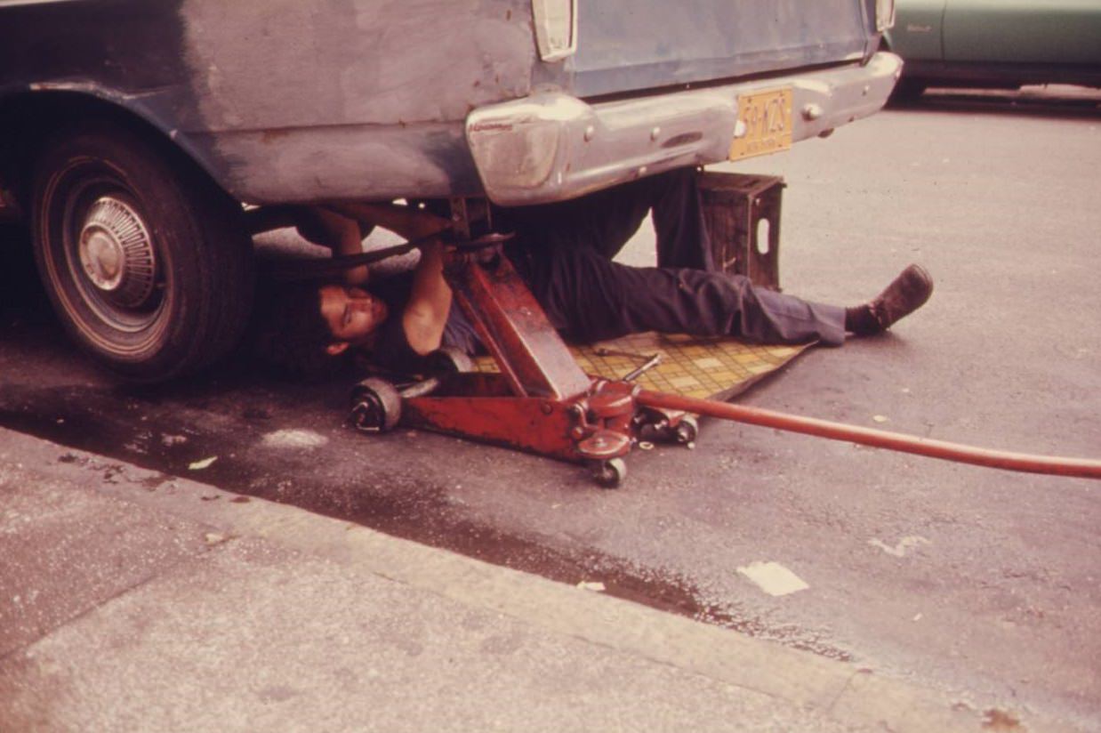 Man working on his car in Hell’s Kitchen, NYC, June 1974.